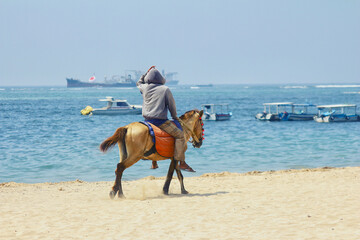 a man who walks on horseback on the beach