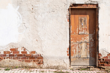 White painted old house with cracked wall surface, old wooden door and closed shutter, No person