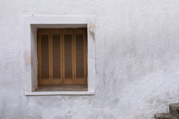 White painted wall with closed window, frame with brown shutter, 
space for text, lock down
