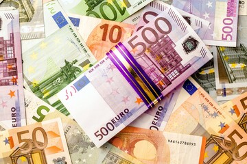 A pack of European currency lies on the background of the Euro

