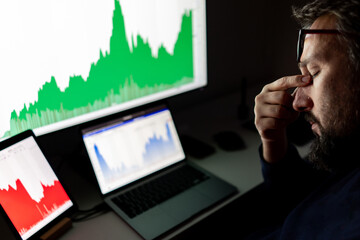 Depressed businessman in front of computer with graph of unsuccessful business on the screen. High quality photo.