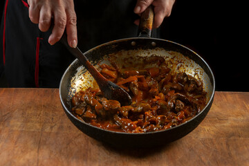 The cook prepares meat with vegetables and onion in a bowl . Oriental cuisine