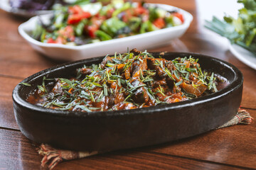 Oriental cuisine:  meat with vegetables and onion in a bowl close-up on the table.