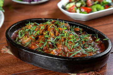 Oriental food, delicious meat sauté in a traditional frying pan.