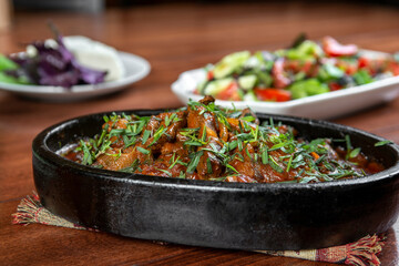 Oriental food, delicious meat sauté in a traditional frying pan.