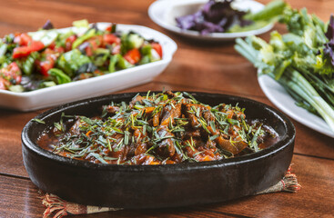 Oriental cuisine:  meat with vegetables and onion in a bowl close-up on the table.