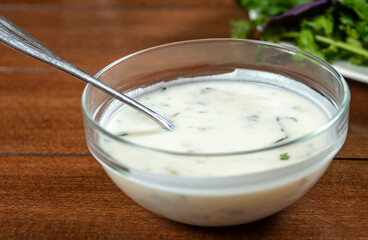 yogurt soup with herbs in a plate on a wooden table.spas