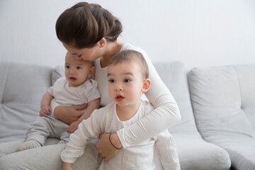 mom plays and reads books with two  little kids. mother spends time with two child sons at home.  place for text. copy space. family time at home
