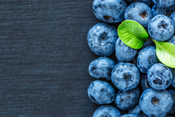 Water drops on ripe sweet blueberry. Fresh blueberries background with copy space for your text. Vegan and vegetarian concept. Macro texture of blueberry berries.Texture blueberry berries close up