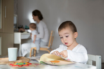 mother tries to work on the computer  with two young children at home. mother spends time with two young children at home