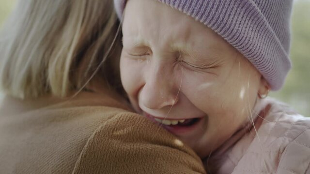 The child cries on the shoulder of the mother, very upset, tears flow