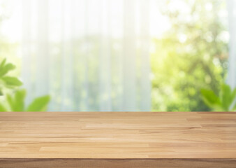 Selective focus.Empty of wood table top on blur of curtain with window view green from garden