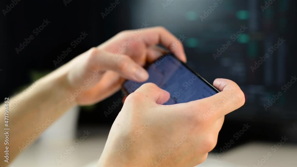 Poster close-up of freelancer analyzing stock exchange chart using mobile app on smartphone while sitting a