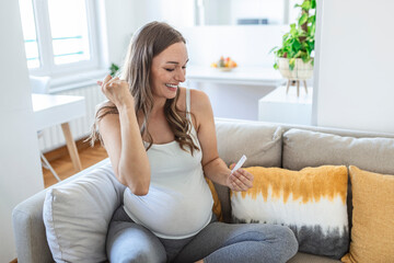 Close-up shot of Pregnant woman's hand holding a negative test device. Happy Pregnant woman showing her negative Coronavirus - Covid-19 rapid test. Coronavirus