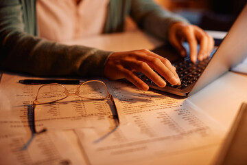 Close-up of woman working late on laptop at home.