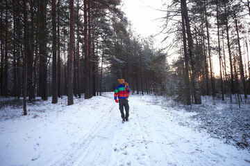 man traveler with a backpack in the forest, winter view in the american forest, north america...