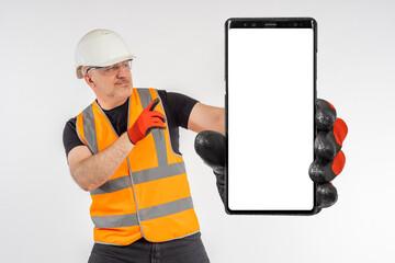 Big phone. Man builder shows smart phone. Foreman in builder uniform. Phone white screen for your...