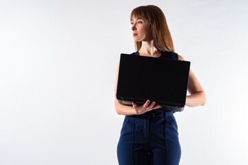 Studio portrait businesswoman. Businesswoman posing with laptop. She is standing and holding a laptop. Modern office worker. Woman office worker on white background. Place for inscription.