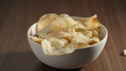 potato chips with black pepper in white bowl on wood table
