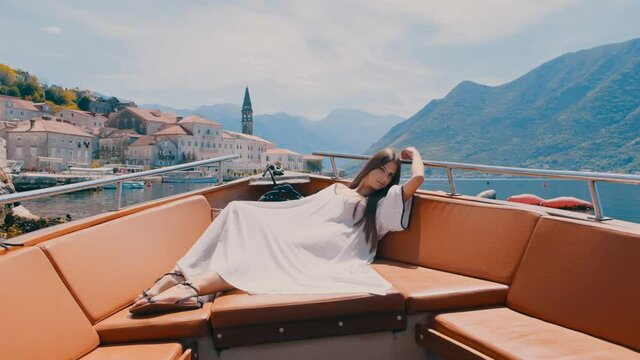 beautiful attractive woman posing on luxury boat. Beautiful woman posing on yacht in elegant summer dress. fashion model. attractive woman looking directly at camera
