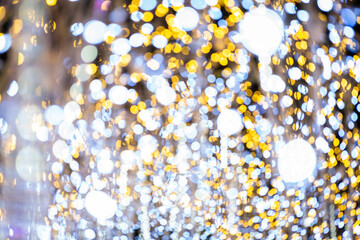 Blurred background of lighting bokeh in yellow and white color for festive decoration. Background...