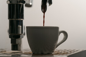 pulling espresso shot with single spout portafilter from coffee machine closeup
