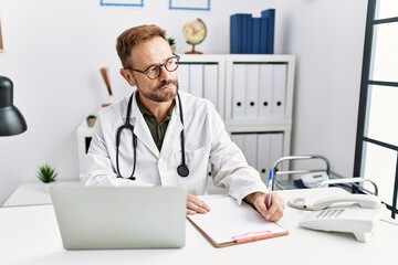 Middle age hispanic man wearing doctor uniform working at clinic