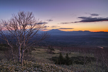 Fototapeta na wymiar グラデーションの空と山々のシルエットを背景に下夜明けの風景。