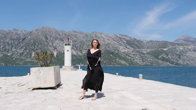 Portrait of gorgeous girl looking to camera. tall sexy brunette woman. woman in blue dress blowing her hair in the wind. mysterious beautiful woman outdoors