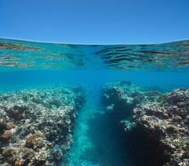 Natural trench in the reef in the sea and blue sky, underwater seascape, split view over and under water surface, south Pacific ocean, French Polynesia