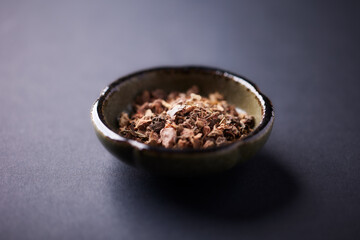 Dry root of Rhodiola rosea. Golden root, rose root. Healthy medical plant on dark paper background. Close up. Copy space.