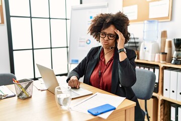 African american woman with afro hair working at the office wearing operator headset worried and stressed about a problem with hand on forehead, nervous and anxious for crisis