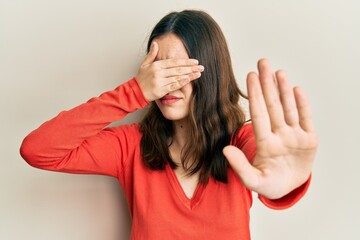 Young brunette woman wearing casual clothes covering eyes with hands and doing stop gesture with sad and fear expression. embarrassed and negative concept.