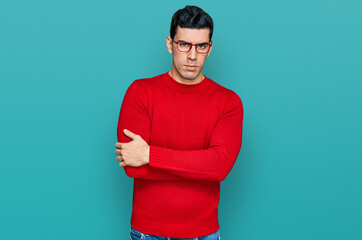 Handsome hispanic man wearing casual clothes and glasses skeptic and nervous, disapproving...
