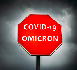 Covid-19 Omicron written on stop sign with stormy clouds in the background