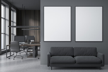 Dark coworking interior with armchairs and pc, sofa and mockup posters