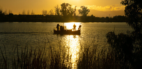 Ebre canal at sunrise with fisherman boat