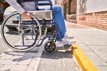 Middle age hispanic man wearing business clothes sitting on wheelchair at street
