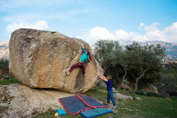 bouldering on rocks, girl climbs a big stone