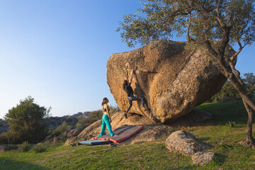 A strong girl climbs a large boulder © zhukovvvlad