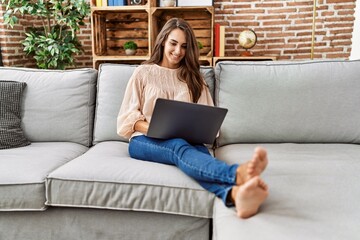 Young hispanic woman smiling confident using laptop at home