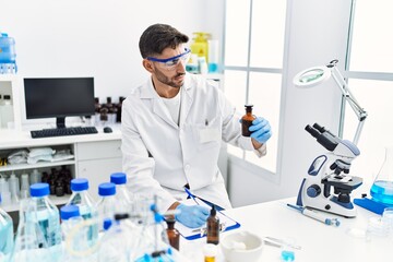 Handsome hispanic man working as scientific at laboratory