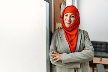 Young woman wearing arabic scarf standing with arms crossed gesture at office