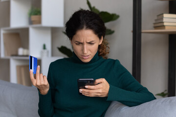 Internet scam. Concerned young hispanic lady looking on smartphone screen having finance savings...