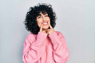 Young middle east woman wearing casual clothes smiling with open mouth, fingers pointing and forcing cheerful smile