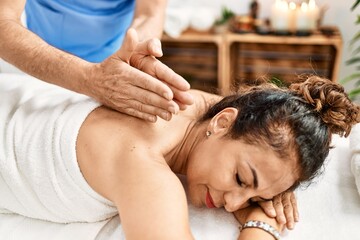Middle age man and woman wearing therapist uniform having back massage session at beauty center