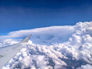 Fototapeta na wymiar View of blue cloudy sky from airplane window