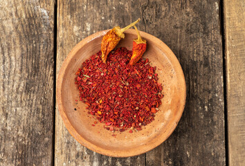 Ground hot peppers on a background from an old tree.