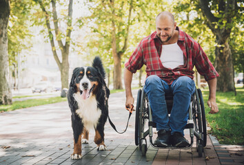 Happy young man with a physical disability in a wheelchair with his dog.