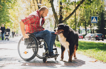 Happy young man with a physical disability in a wheelchair with his dog.